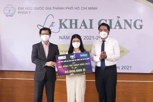ThS Nguyễn Thanh Nguyên (phải) trao học bổng của Quỹ Phát triển ĐHQG-HCM cho thủ khoa tuyển sinh của Khoa Y ĐHQG-HCM. Ảnh: vnuhcm