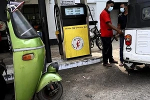 Nhân viên đổ xăng cho xe ôtô tại một trạm xăng dầu ở Colombo. Ảnh: AFP
