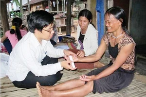 Bác sĩ của Bệnh viện Da liễu Trung ương thăm khám cho người dân ở Ba Tơ bị hội chứng viêm da dày sừng bàn tay bàn chân