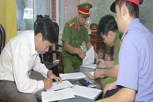 Lê Hữu Lam ký vào các giấy tờ liên quan trước khi bị bắt