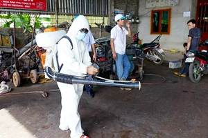  Nhân viên y tế phun thuốc diệt muỗi ngăn ngừa bệnh SXH bùng phát ở nhà dân