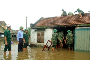 Lực lượng chức năng giúp người dân lợp lại mái nhà sau lốc xoáy ở xã Xuân Phổ, huyện Nghi Xuân, tỉnh Hà Tĩnh