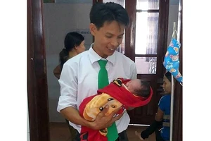Tài xế Nguyễn Đăng Ngự bên cháu bé mới sinh 