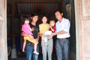 Ông Nguyễn Đức Tuấn, Phó Chủ tịch UBND xã Hồng Lộc (huyện Lộc Hà, tỉnh Hà Tĩnh) trao 35 triệu đồng của bạn đọc Báo SGGP cho gia đình vợ chồng anh Trung, chị Chi