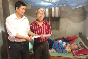 Đại diện UBND xã Đức Bồng, huyện Vũ Quang trao 12 triệu đồng của bạn đọc Báo SGGP cho gia đình anh Trần Sinh Nhật