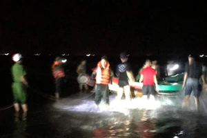 Lực lượng chức năng và người dân đưa thuyền gặp nạn vào bờ