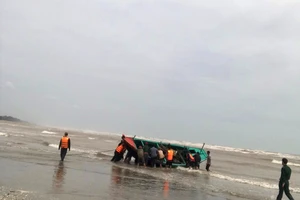 Lực lượng chức năng và người dân tham gia trục vớt thuyền bị nạn đưa vào bờ