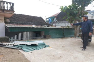 Ông Phan Đình Ngọc (thôn Tân Tiến, xã Phú Lộc) bên cổng nhà bị bịt kín sau khi nâng đường phía trước. Ảnh chụp ngày 2-2-2023