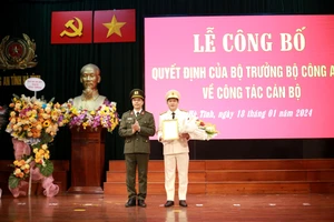 Đại tá Nguyễn Hồng Phong, Giám đốc Công an tỉnh Hà Tĩnh trao quyết định và tặng hoa chúc mừng Trung tá Nguyễn Quốc Hùng