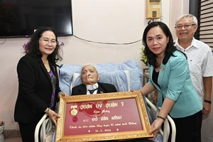 Phó Bí thư Thành ủy Nguyễn Thị Lệ chúc mừng đồng chí Đỗ Văn Minh nhận Huy hiệu Đảng. Ảnh: VIỆT DŨNG