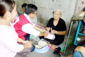 Các hội viên Hội Chữ thập đỏ phường 6, quận 4 tặng cơm các cụ già nghèo khó, neo đơn