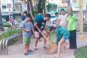 Các bé trong tổ bảo vệ Kim Đồng dọn vệ sinh trong công viên