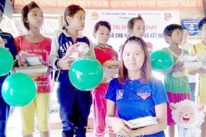 Chị Nguyễn Thị Như Ngọc (hàng đầu) trao quà cho trẻ có hoàn cảnh khó khăn