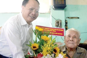 Ủy viên Trung ương Đảng, Phó Bí thư Thường trực Thành ủy TPHCM Tất Thành Cang trao tặng đồng chí Lý Toàn Anh Huy hiệu 70 năm tuổi Đảng