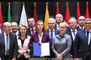 Đại diện Cấp cao phụ trách chính sách an ninh và đối ngoại EU Federica Mogherini (giữa) sau lễ ký. TTXVN