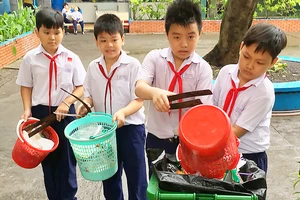Học sinh Trường Tiểu học Lý Nhân Tông, quận 8 (TPHCM) thu gom rác ở trường, thực hiện phân loại rác tại nguồn Ảnh: THÀNH TRÍ