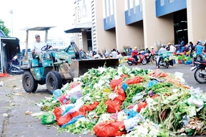 Thu dọn rác tại một bãi tập kết rác ở chợ Bình Điền Ảnh: THÀNH TRÍ