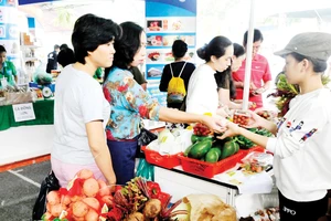 Người tiêu dùng mua rau củ quả tại gian hàng của tỉnh Lâm Đồng trong hội nghị Kết nối cung - cầu hàng hóa giữa TPHCM và các tỉnh, thành năm 2017 Ảnh: THÀNH TRÍ