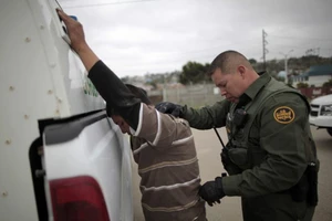 Lực lượng an ninh bắt giữ người nhập cư bất hợp pháp vào Mỹ. Ảnh: REUTERS
