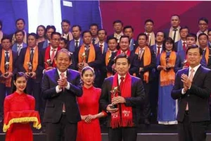 Phó Thủ tướng Thường trực Chính phủ Trương Hòa Bình và Bí thư thứ nhất Trung ương Đoàn TNCS Hồ Chí Minh trao Giải thưởng Sao Đỏ cho các Doanh nhân trẻ Việt Nam tiêu biểu năm 2017. Ảnh: TTXVN