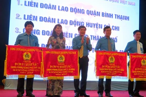 Chủ tịch Tổng LĐLĐ Việt Nam Bùi Văn Cường trao cờ xuất sắc chúc mừng các tập thể