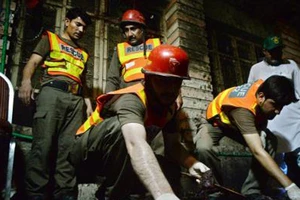 Nhân viên cứu hộ Pakistan làm nhiệm vụ tại hiện trường vụ đánh bom đẫm máu ở Peshawar ngày 10-7. Nguồn TTXVN
