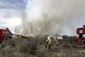 Nhân viên cứu hộ và cứu hỏa tại hiện trường máy bay chở khách Embraer của hãng Aeromexico rơi gần sân bay Durango, Mexico, ngày 31-7-2018. Ảnh do Cơ quan Phòng vệ Dân sự bang Durango công bố