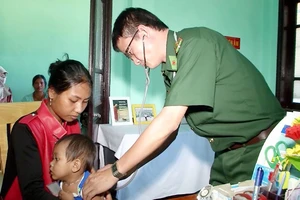 Bác sĩ Đặng Hồng Minh khám bệnh cho đồng bào các dân tộc khu vực biên giới Việt Nam - Lào