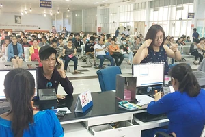 Người dân lấy số thứ tự chờ mua vé tàu Tết tại ga Sài Gòn