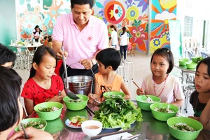 Các em nhỏ ở Cô nhi viện Thiên Bình (Đồng Nai) dùng bữa cơm có thịt do tình nguyện viên nấu