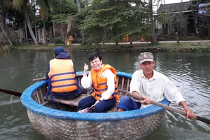 Nông dân chèo thuyền thúng đưa khách tham quan sông Cổ Cò. Ảnh: TRUNG CHÂU