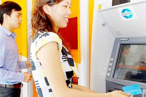 Khách hàng sử dụng thẻ ATM ngân hàng Ảnh: THÀNH TRÍ
