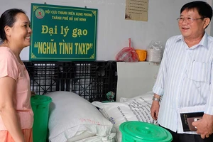 Ông Tống Văn Lường thăm hỏi và hướng dẫn cho đồng đội tại đại lý gạo “Nghĩa tình TNXP” quận Tân Bình