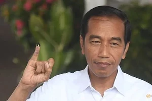 Tổng thống Indonesia Joko Widodo giơ ngón tay in mực sau khi bỏ phiếu tại thủ đô Jakarta. Ảnh: REUTERS