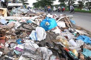 Một bãi rác tự phát trên đường Nguyễn Văn Linh (huyện Bình Chánh). Ảnh: CAO THĂNG