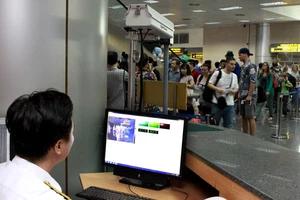 Sử dụng máy đo thân nhiệt tia hồng ngoại nhằm kiểm soát dịch bệnh ở sân bay Nội Bài. Ảnh: TTXVN