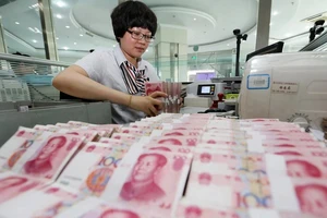 Kiểm tiền NDT tại ngân hàng ở Lianyungang, tỉnh Giang Tô, miền Đông Trung Quốc ngày 11-8. Nguồn: TTXVN