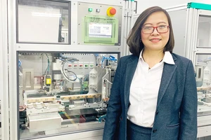 Chị Công Tằng Tôn Nữ Thùy Trang bên hệ thống dây chuyền sản xuất các thiết bị đa năng tại Công ty ITO Việt Nam