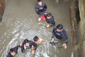 Thượng úy Trần Thành Phát cùng đồng đội đưa nạn nhân mắc kẹt trong cống thoát nước ra ngoài 