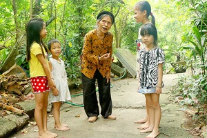 Nghệ nhân ưu tú Nguyễn Thị Vẫy dạy hát Trống quân cho thiếu nhi ngay tại vườn nhà mình