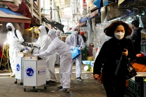 Các nhân viên khử trùng một khu chợ truyền thống ở thủ đô Seoul, Hàn Quốc. Ảnh: REUTERS 