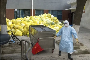 Một công nhân vệ sinh xử lý rác thải y tế tại một bệnh viện ở Thành phố Vũ Hán, Trung Quốc. Ảnh: XINHUA