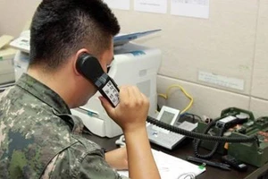 Bộ Thống nhất Hàn Quốc cho biết, đến trưa 9-6, việc liên lạc qua điện thoại với Triều Tiên đã không thể thực hiện được. Trong ảnh: Một sĩ quan Quân đội Hàn Quốc đang sử dụng đường dây nóng quân sự để liên lạc với Triều Tiên. Ảnh: YONHAP 