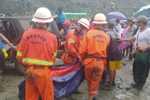  Lực lượng cứu hộ đưa thi thể ra khởi nơi xảy ra lở đất ở bangKachin, Myanmar ngày 2-7. Ảnh: REUTERS