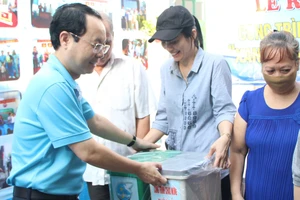 Bí thư Quận ủy quận 5 Nguyễn Văn Hiếu tặng thùng rác cho các hộ gia đình tại lễ ra mắt hẻm xanh - sạch - văn minh ở phường 1, quận 5. Ảnh: MAI HOA