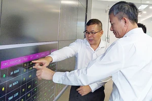 Tổng Giám đốc EVNHCMC Nguyễn Văn Thanh (bìa trái) đang báo cáo về hệ thống điều khiển từ xa tại Trung tâm Điều độ hệ thống điện TPHCM với Tổng Giám đốc EVN Trần Đình Nhân