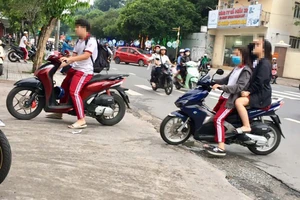 Một số học sinh sử dụng xe máy trên 50cc để đi học, không đội nón bảo hiểm