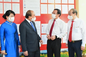 Chủ tịch nước Nguyễn Xuân Phúc trao đổi cùng Bí thư Thành ủy TPHCM Nguyễn Văn Nên sau khi bỏ phiếu. Ảnh: VIỆT DŨNG