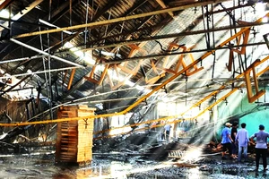 Lực lượng chức năng, công nhân nỗ lực dập tắt đám cháy kho nhà xưởng TP Quy Nhơn, Bình Định trong ngày 30-7. Ảnh: XUÂN HUYÊN