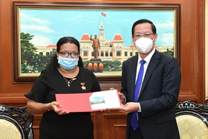 Đồng chí Phan Văn Mãi trao tặng Huy hiệu TPHCM cho đồng chí Indira Lopez Arguelles. Ảnh: VIỆT DŨNG